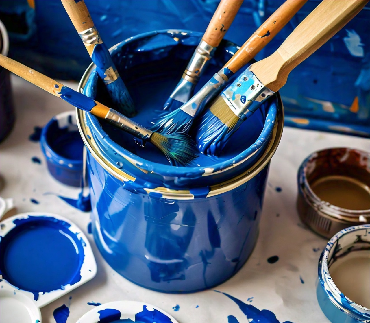 Several paintbrushes dipped in various shades of blue paint, resting in and around an open paint can.